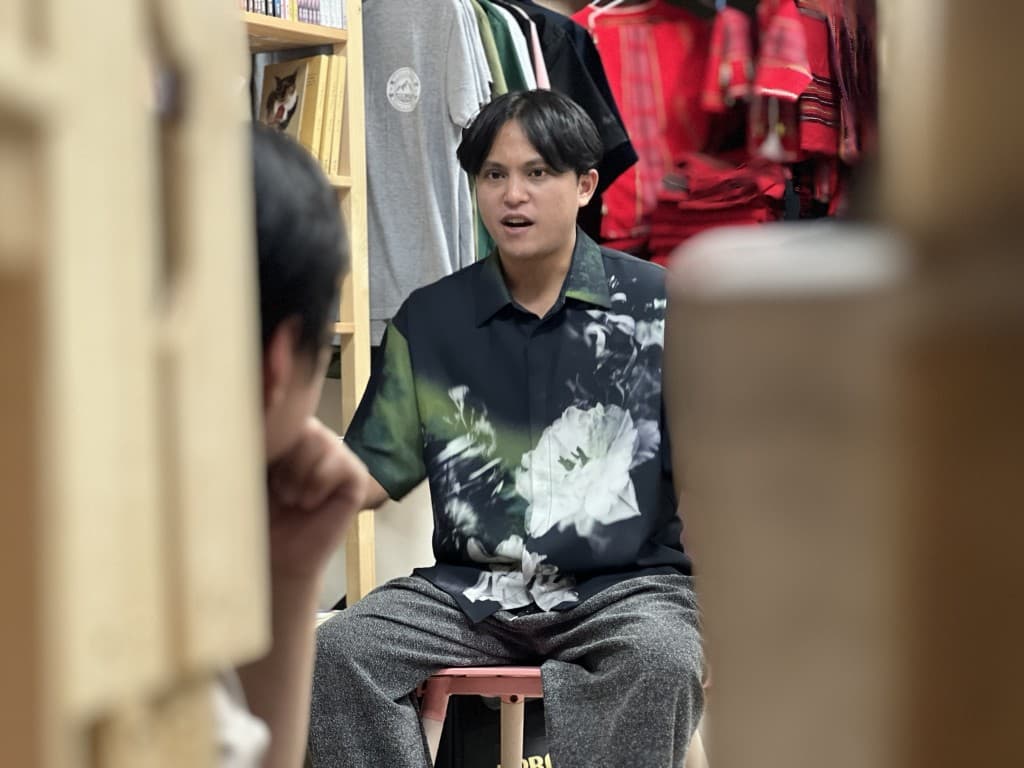 青年在服飾與泰雅織品之間說明自己對音樂與地方的想法