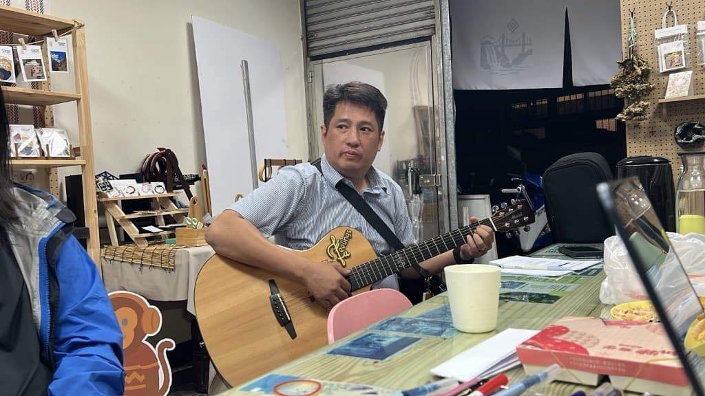 音樂人在角板山空間裡抱著吉他,準備把還沒完成的歌唱出來