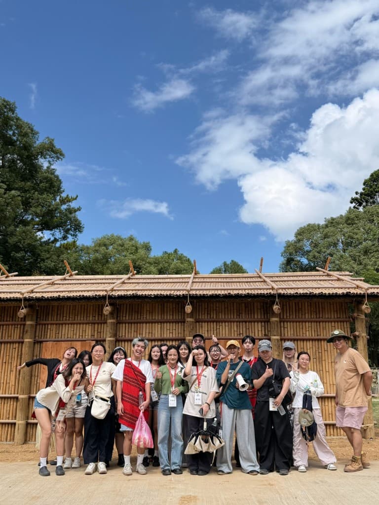 The group standing in front of a bamboo building during the Jiaobanshan walk