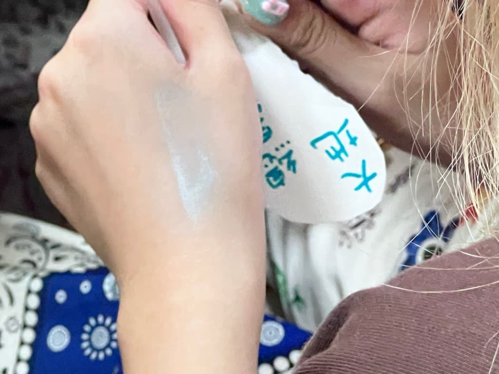 White cultural pigment on a student’s hand, beside a sheet of handwritten notes