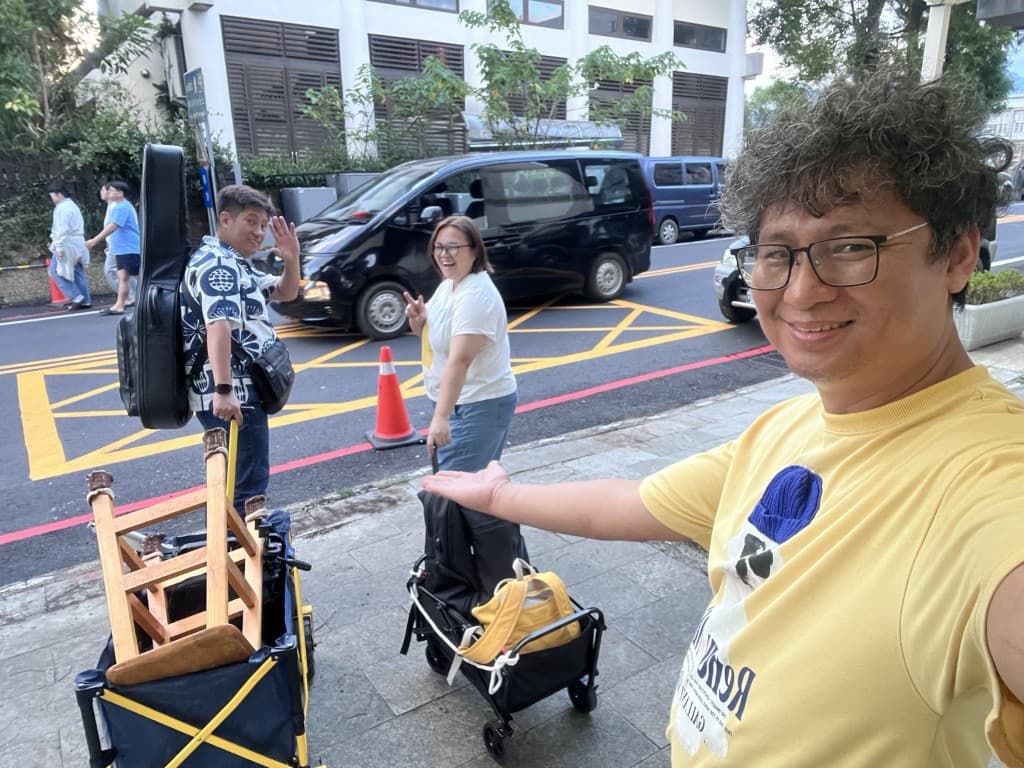 張一凡與同伴一起搬運吉他與器材,準備或收拾自主音樂實踐